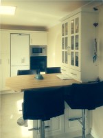 Stylish cream kitchen with simple straight lines and breakfast bar styled kitchen table - designed and fitted by Barrett Kitchens, Milford, Letterkenny, Co. Donegal, Ireland