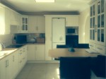 Stylish cream kitchen with simple straight lines and breakfast bar styled kitchen table - designed and fitted by Barrett Kitchens, Milford, Letterkenny, Co. Donegal, Ireland