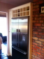 Kitchen unit encompassing fridge and freezer and overhead wine rack - designed and fitted by Barrett Kitchens, County Donegal, Ireland