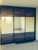 Sliding robe with gloss and wood panels - bedroom units designed and fitted by Barrett Kitchens, Donegal, Ireland